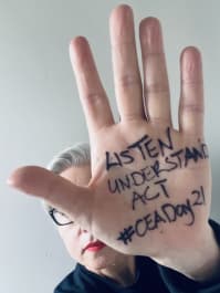 A hand with the words "listen, understand, act. #CEADay21" written on it